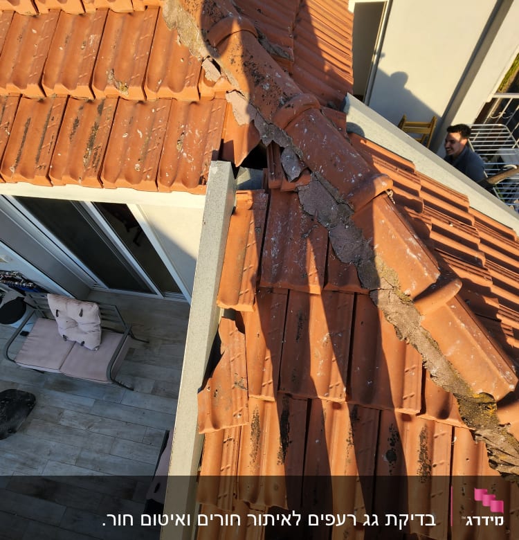 רעפים כתומים על גג עם סימני בלאי ותיקון